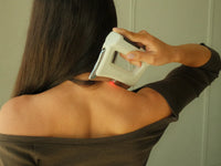 FasciaWave held on the top of the shoulder